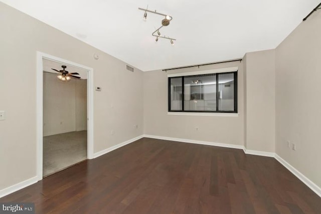 empty room featuring ceiling fan and dark wood-type flooring