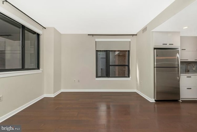 spare room featuring sink and dark wood-type flooring