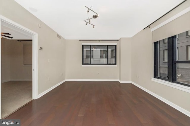 empty room with dark hardwood / wood-style floors and ceiling fan