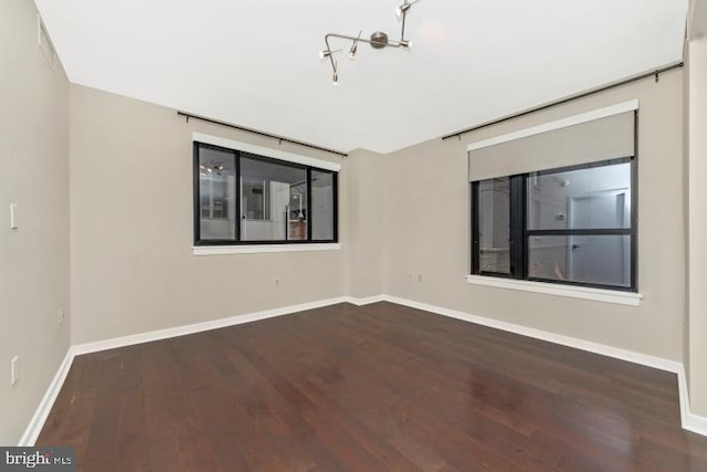 unfurnished room with dark hardwood / wood-style flooring