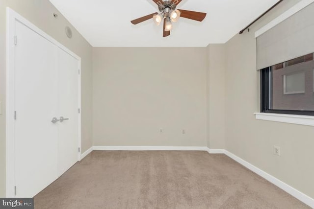 carpeted spare room featuring ceiling fan