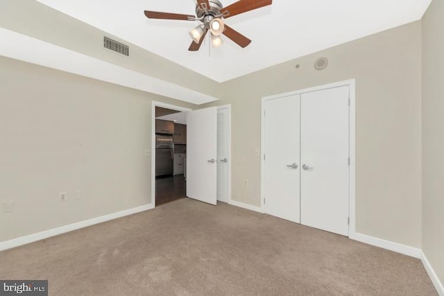 unfurnished bedroom featuring ceiling fan, light colored carpet, and stainless steel fridge