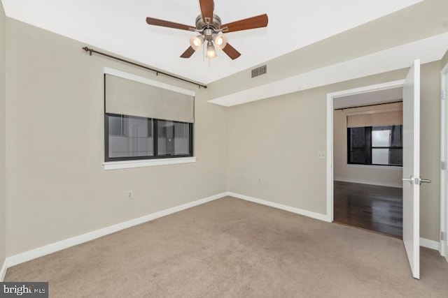 empty room with ceiling fan and light colored carpet