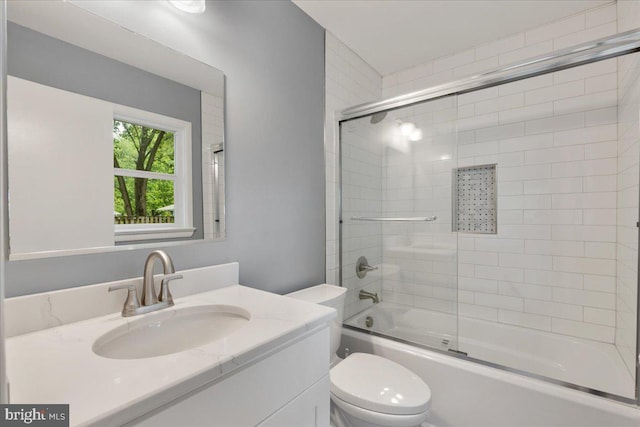 full bathroom with combined bath / shower with glass door, vanity, and toilet