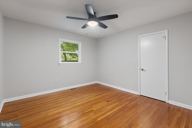 empty room with hardwood / wood-style floors and ceiling fan