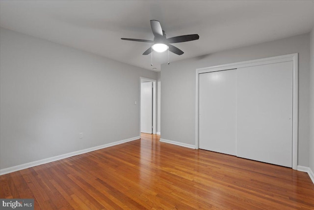 unfurnished bedroom with ceiling fan, light hardwood / wood-style flooring, and a closet