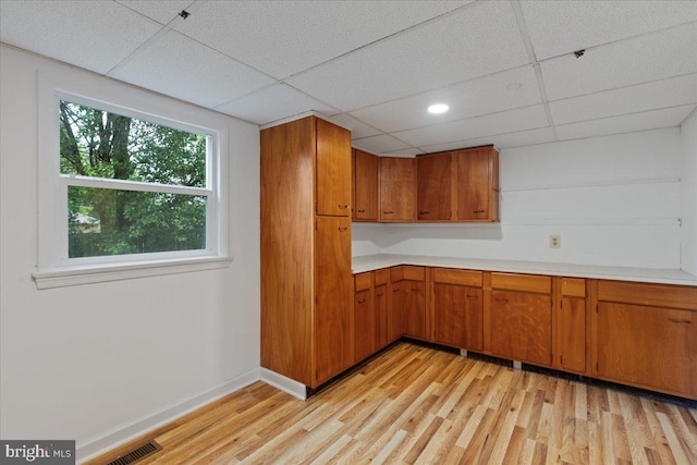 kitchen with light hardwood / wood-style floors and a paneled ceiling