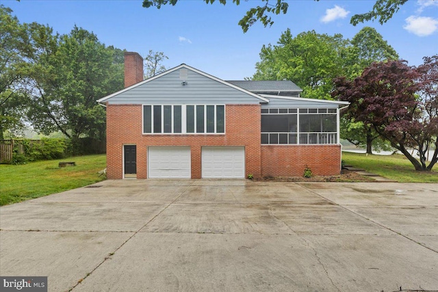 view of front facade with a sunroom, a front lawn, and a garage