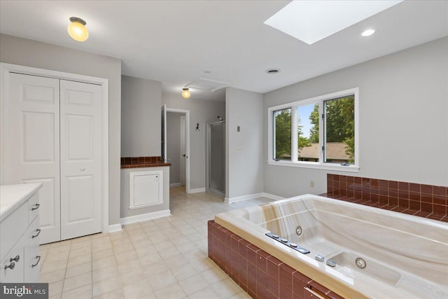 bathroom with vanity, a skylight, and plus walk in shower