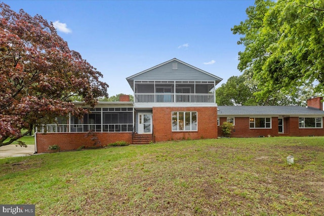 back of property featuring a sunroom and a yard