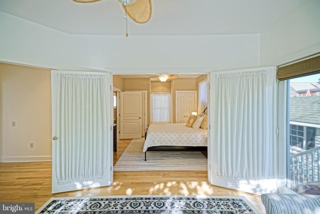 bedroom featuring access to outside, light hardwood / wood-style flooring, and ceiling fan