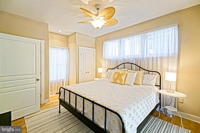 bedroom with light hardwood / wood-style floors, multiple windows, and ceiling fan