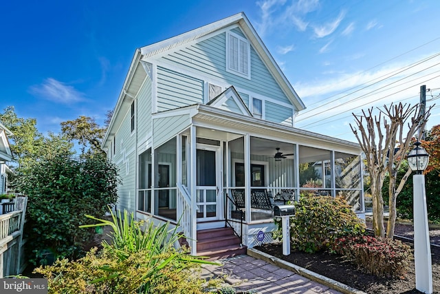 view of front of house featuring a sunroom and ceiling fan