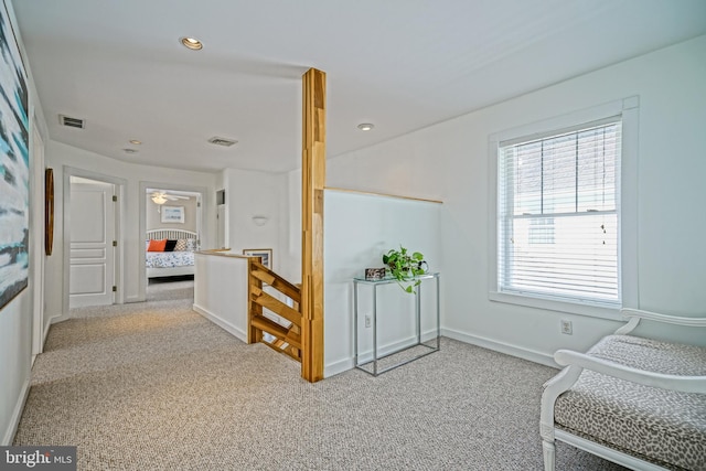 corridor featuring light colored carpet and plenty of natural light