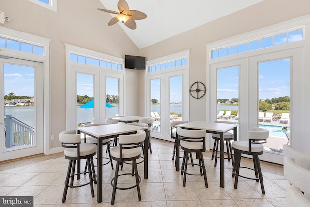 tiled dining space featuring french doors, ceiling fan, and high vaulted ceiling