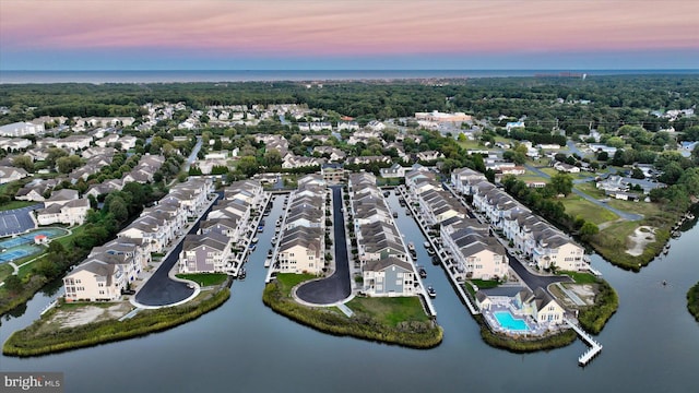 aerial view at dusk featuring a water view