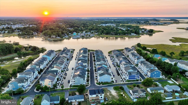 aerial view at dusk featuring a water view