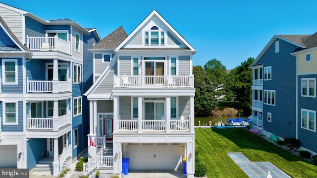 beach home with a balcony, a front lawn, and a garage