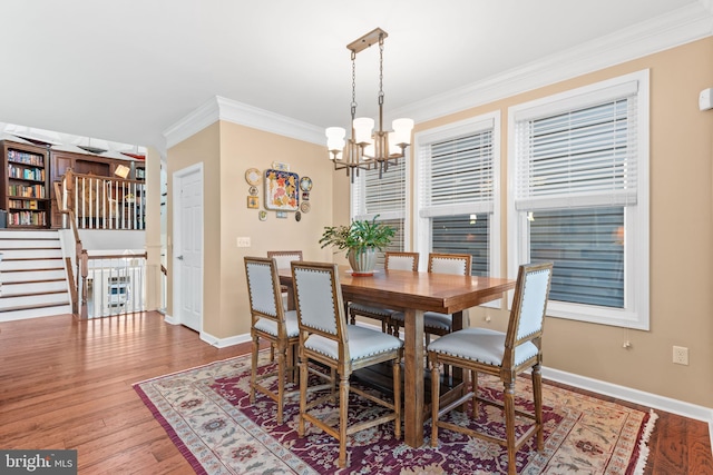 dining area featuring ornamental molding, hardwood / wood-style floors, and a chandelier