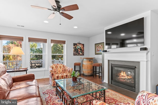 living room featuring dark wood-type flooring and ceiling fan