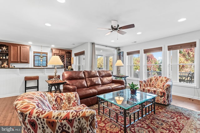 living room with light hardwood / wood-style flooring and ceiling fan