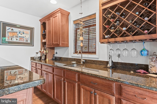 kitchen featuring sink, light hardwood / wood-style flooring, and dark stone countertops