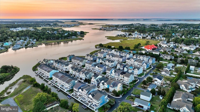 aerial view at dusk featuring a water view