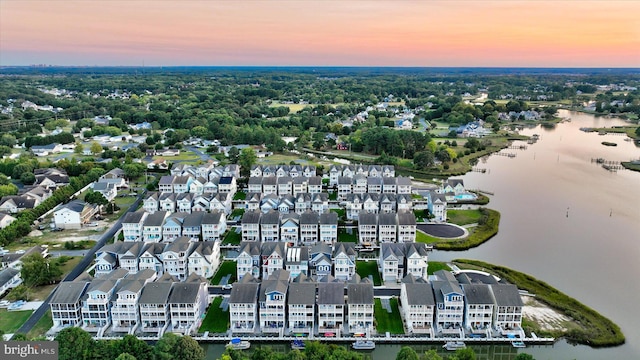 aerial view at dusk featuring a water view