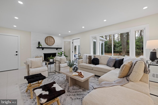 living area featuring a large fireplace, light tile patterned floors, and recessed lighting