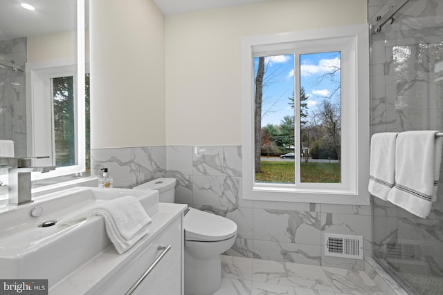 bathroom with a marble finish shower, visible vents, toilet, marble finish floor, and vanity