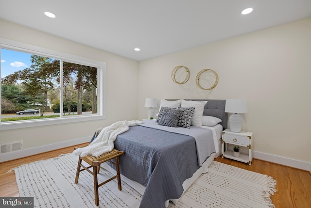 bedroom featuring visible vents, baseboards, wood finished floors, and recessed lighting