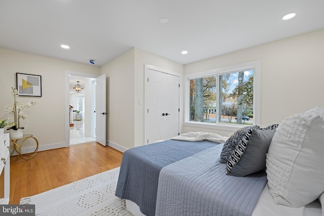 bedroom featuring baseboards, a chandelier, wood finished floors, and recessed lighting