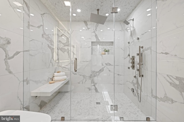 full bath featuring a marble finish shower and tile walls