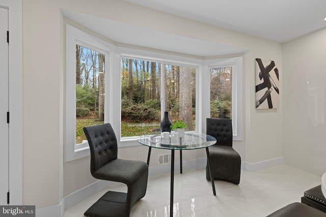 living area with baseboards, visible vents, and tile patterned floors