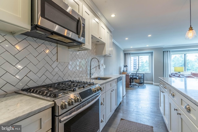 kitchen featuring dark hardwood / wood-style flooring, sink, decorative backsplash, light stone countertops, and appliances with stainless steel finishes