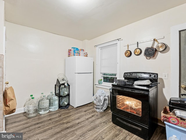 kitchen featuring black range with electric cooktop, white refrigerator, and hardwood / wood-style floors