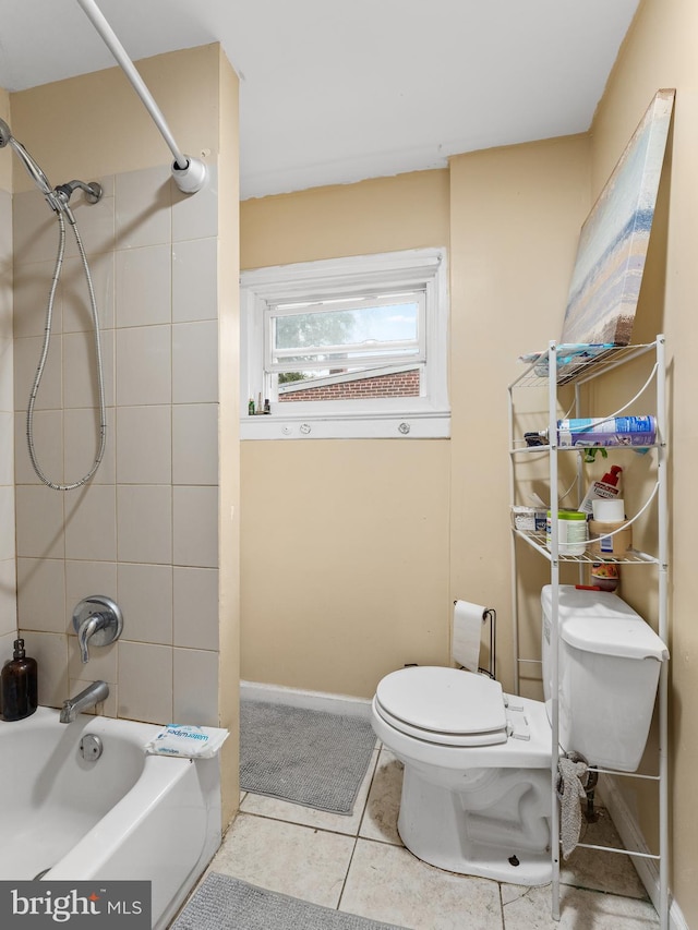 bathroom featuring tile patterned floors, toilet, and tiled shower / bath combo