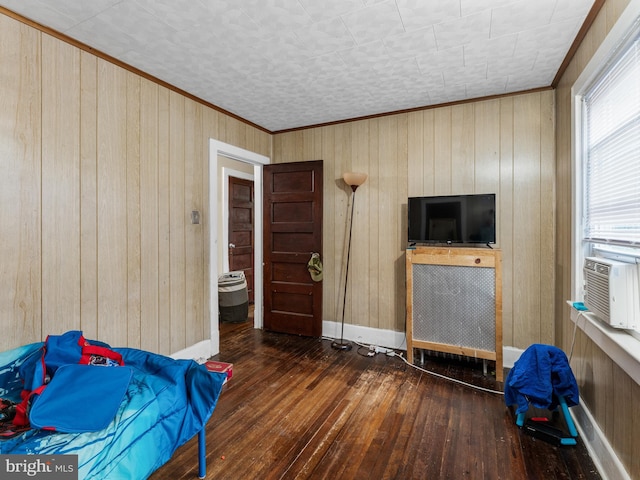 bedroom with wood walls, dark hardwood / wood-style floors, and ornamental molding