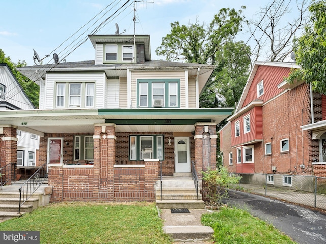 view of front of property featuring a porch, a front lawn, and cooling unit