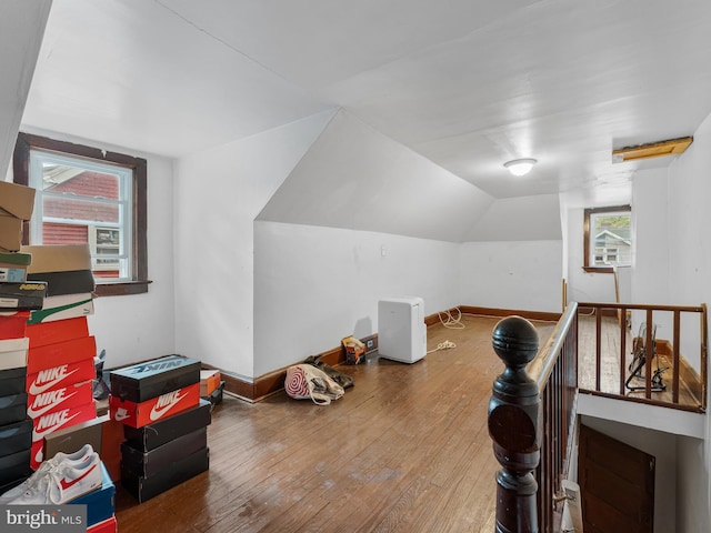 additional living space with vaulted ceiling, hardwood / wood-style flooring, and a wealth of natural light