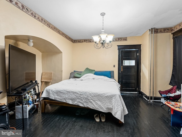 bedroom with a chandelier and dark hardwood / wood-style flooring