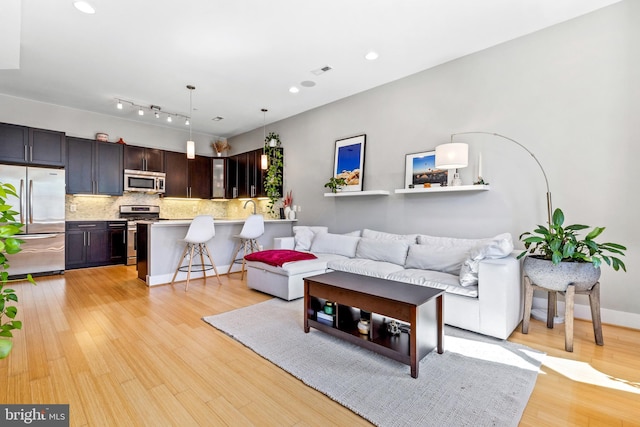 living room with light hardwood / wood-style flooring and sink