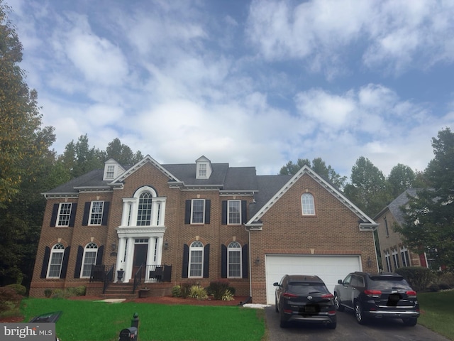 colonial house featuring a front yard and a garage