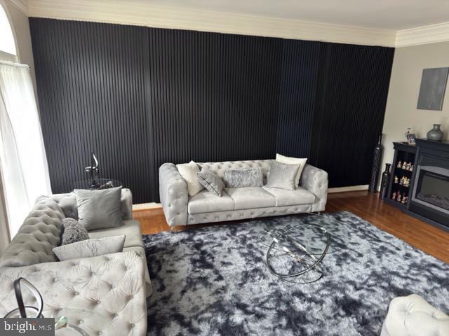 living room with wood-type flooring and crown molding