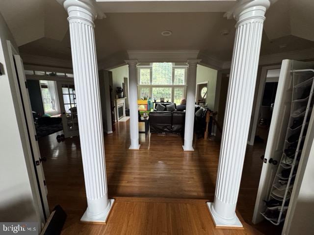 hallway with ornate columns, plenty of natural light, ornamental molding, and hardwood / wood-style flooring