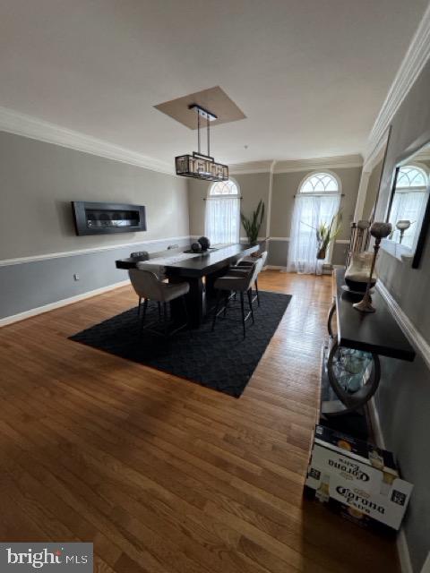 dining area with crown molding and wood-type flooring