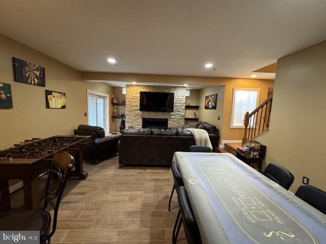 game room featuring a fireplace, light hardwood / wood-style floors, and a healthy amount of sunlight