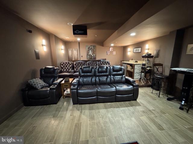 cinema room featuring hardwood / wood-style floors and bar