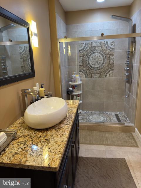 bathroom with an enclosed shower, tile patterned flooring, and vanity