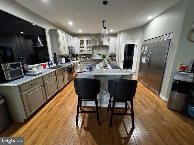 kitchen with a kitchen island, light hardwood / wood-style floors, a kitchen breakfast bar, and stainless steel appliances